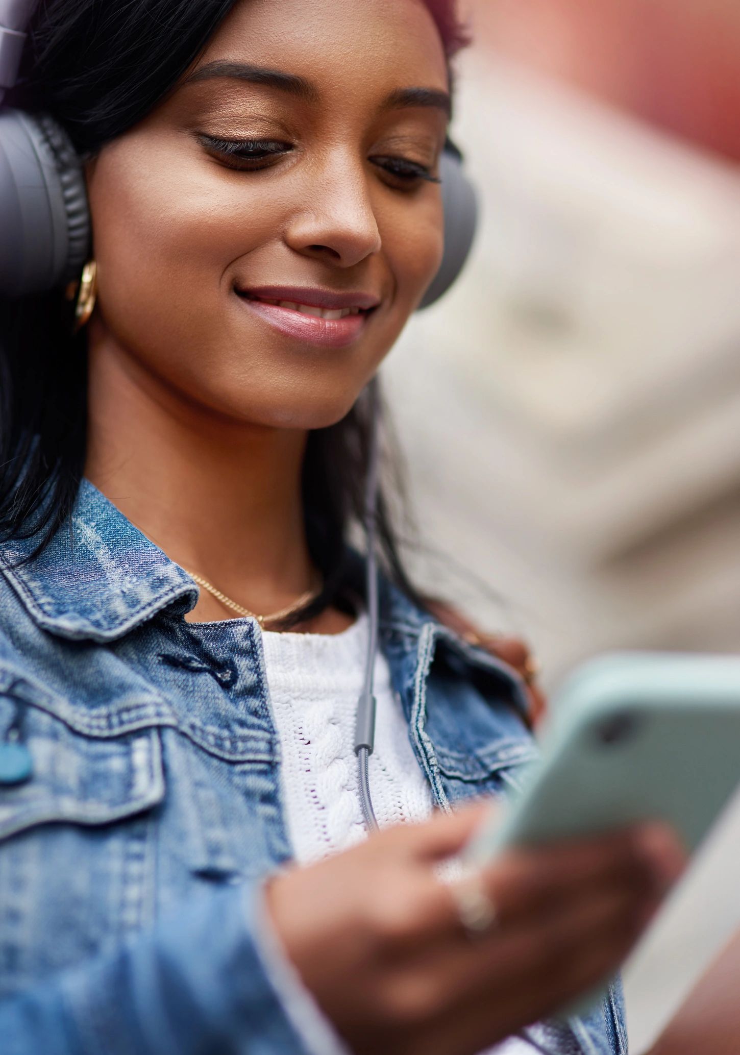 Person using a phone with headphones, streaming audio