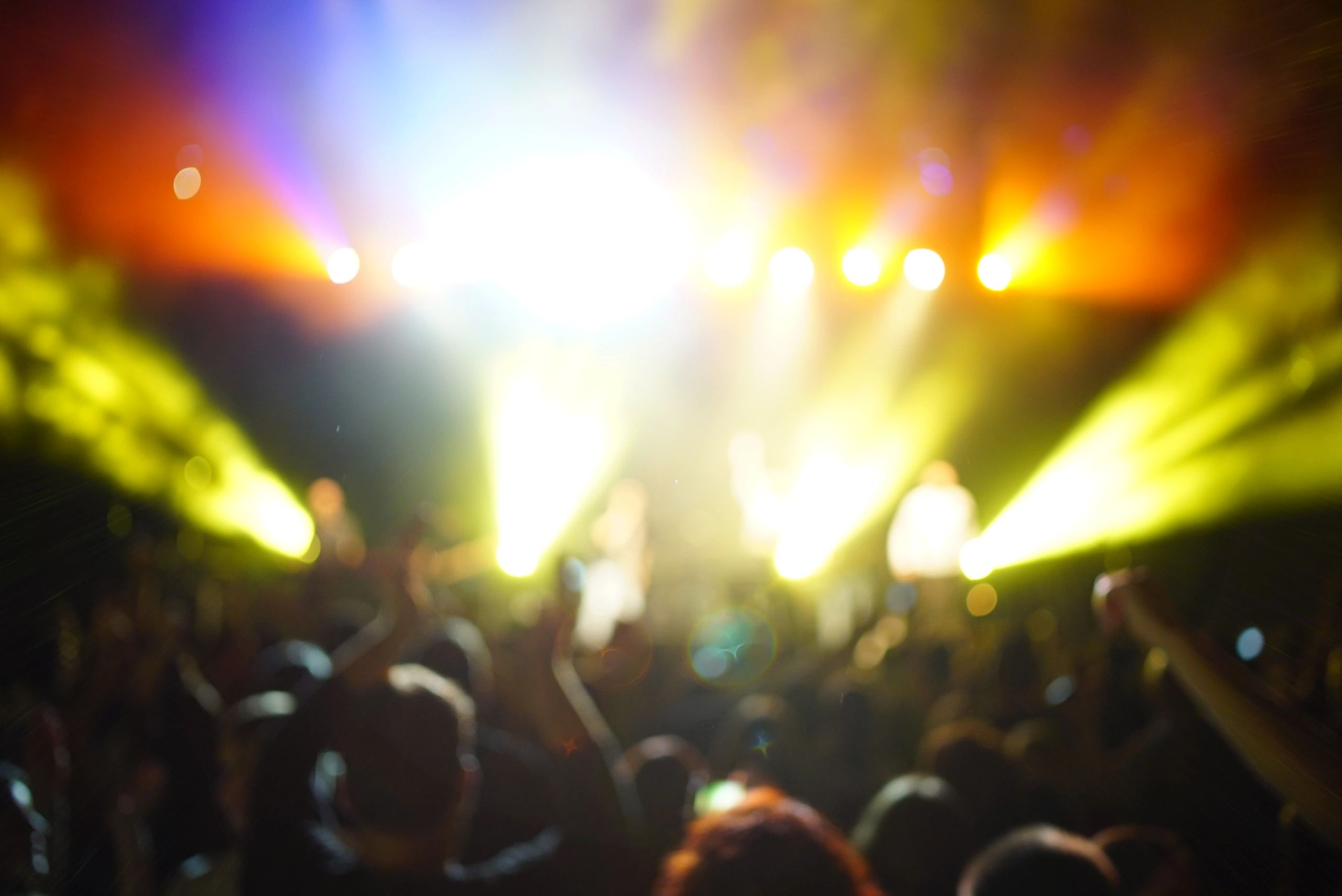 Concert crowd silhouette with bright stage lights